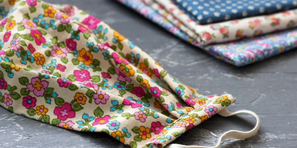 homemade protective mask and pieces of cloth on a gray background selective focus