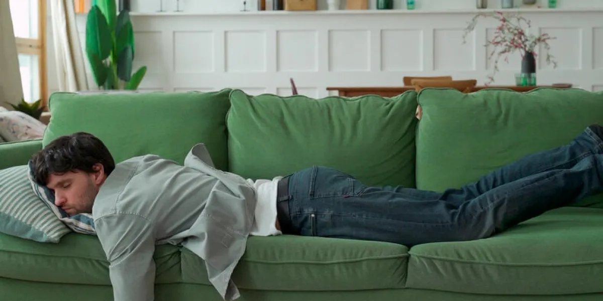exhausted young man came home after work flopped down on sofa