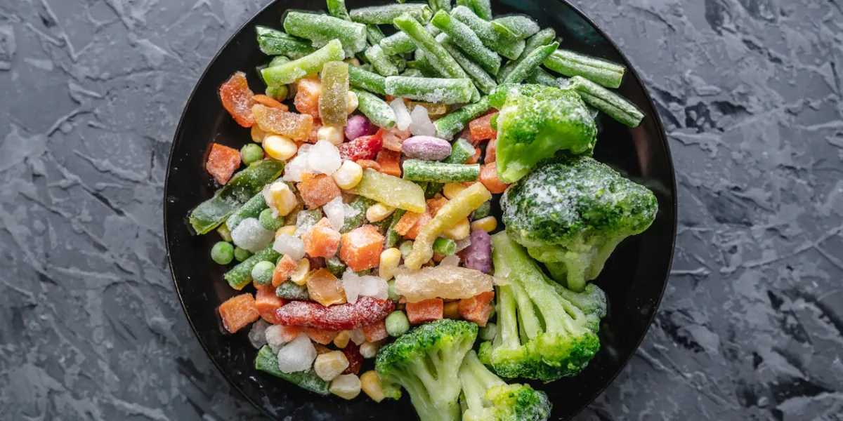 plate of frozen vegetables on a gray table concept of saving time on cooking dinner and convenient storage of ready made frozen dishes