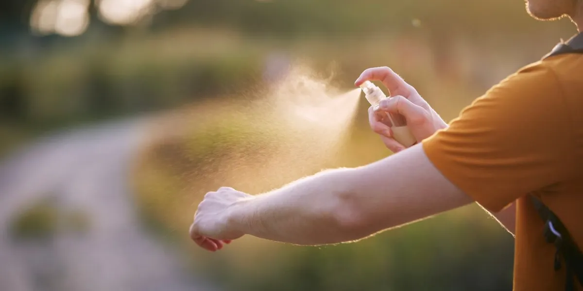 prevention against mosquito bite in tropical destination man applying insect repellent on his handn