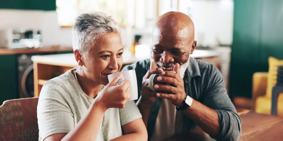 house, coffee and senior couple with love, romance and bonding together with relationship valentines day, old man and mature woman in living room, cappuccino and herbal tea with marriage and smile