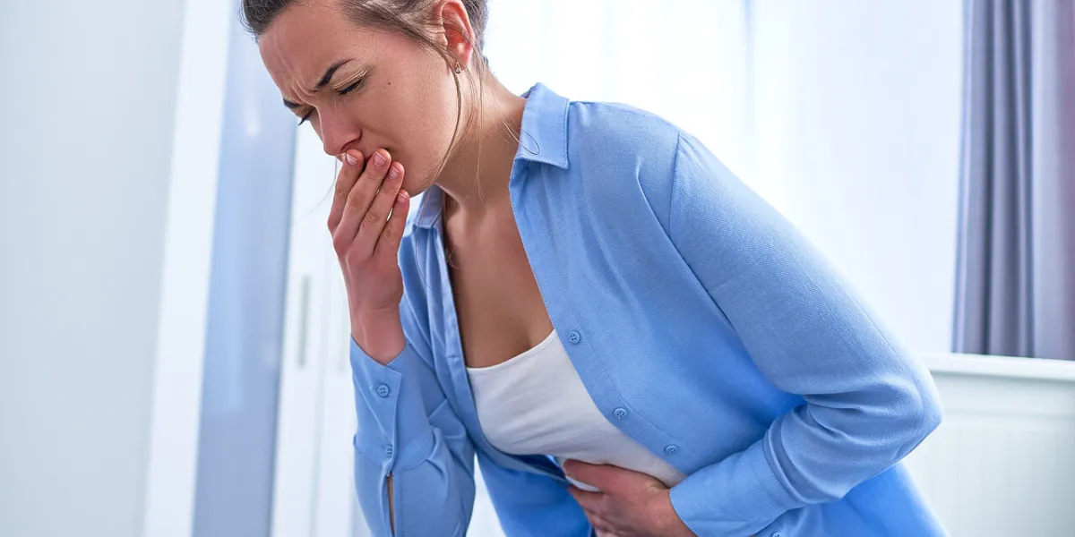 woman suffers from nausea and vomiting during gastrointestinal system disease or food poisoning, health problems