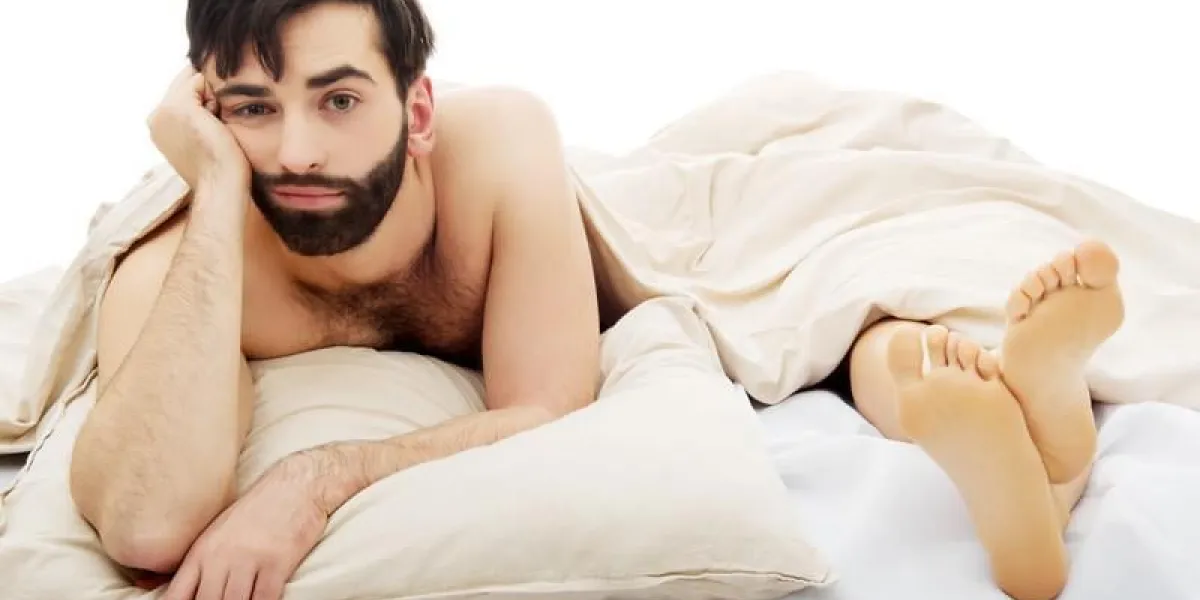 jeune bel homme déprimé dans son lit