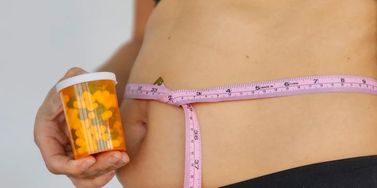 closeup of overweight fat woman taking slimming pills from bottle weight loosing, diet, fat burning, pharmacy, medicine