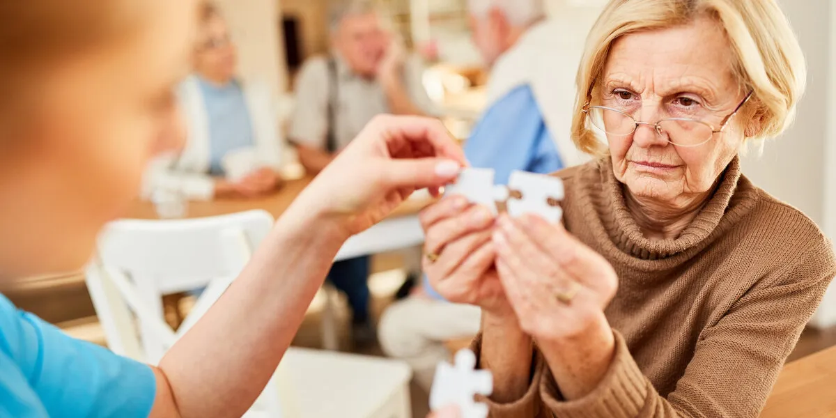 senior with alzheimer's or dementia has difficulty playing puzzle