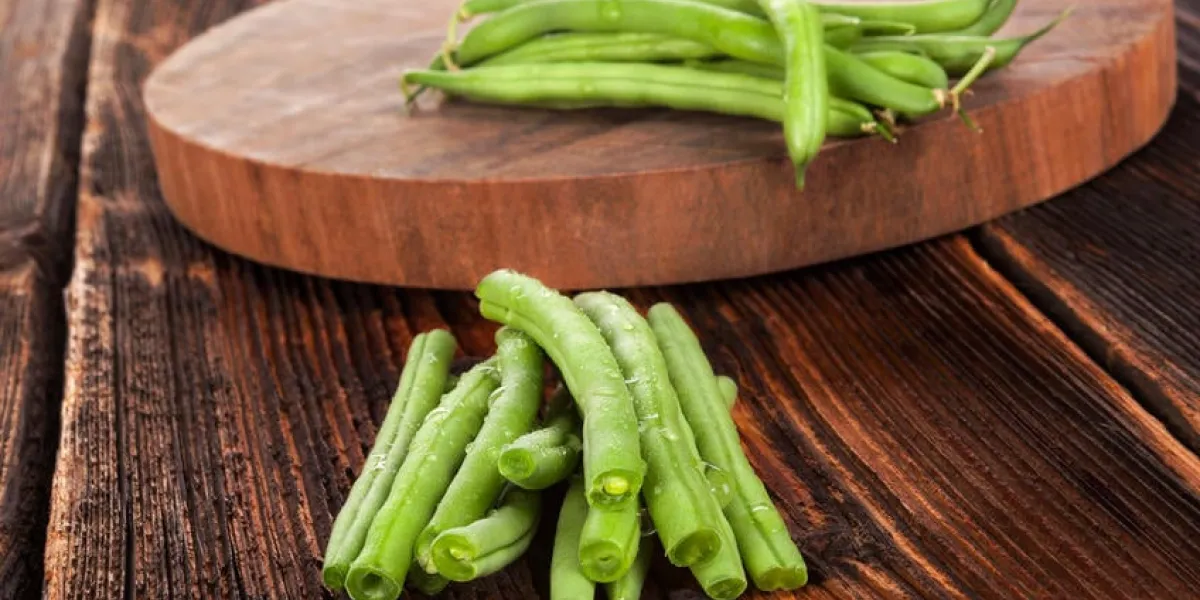 haricots verts frais avec des gouttes d'eau sur la table en bois brun texturé manger des légumes frais
