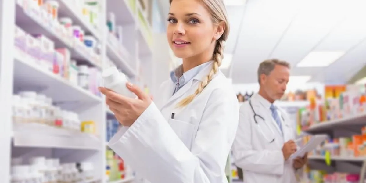 étudiant souriant tenant des médicaments dans la pharmacie