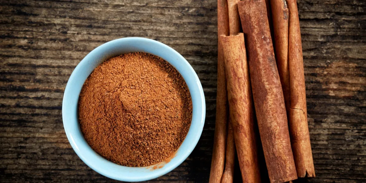 poudre de cannelle et bâtons sur la table en bois