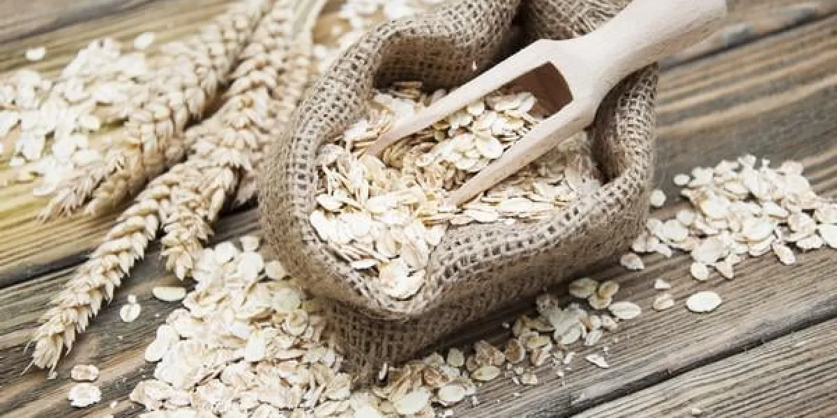 petit sac de jute avec de l'avoine sur un fond en bois foncé