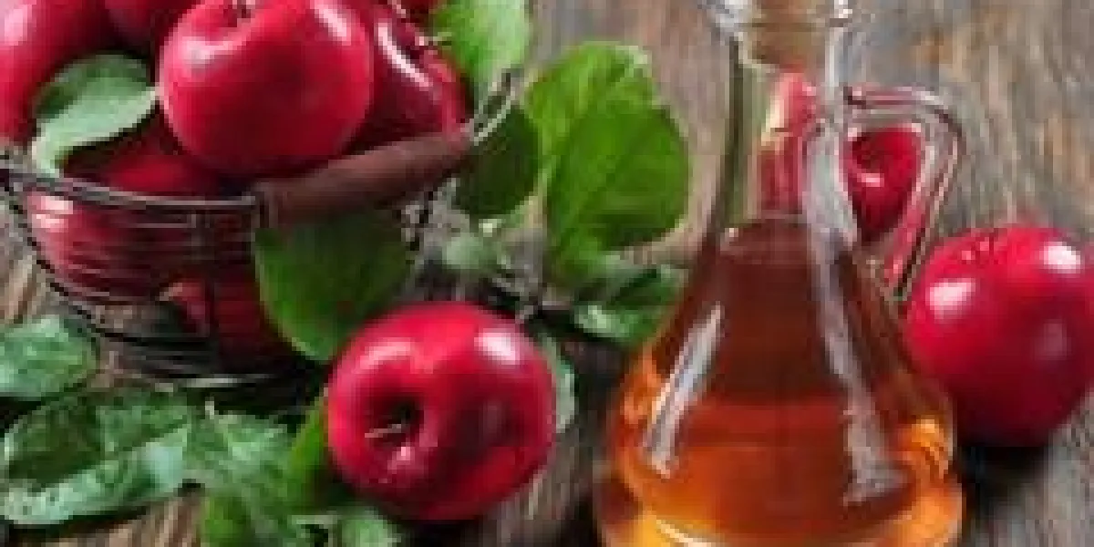 vinaigre de cidre de pomme en bouteille de verre et panier avec des pommes fraîches