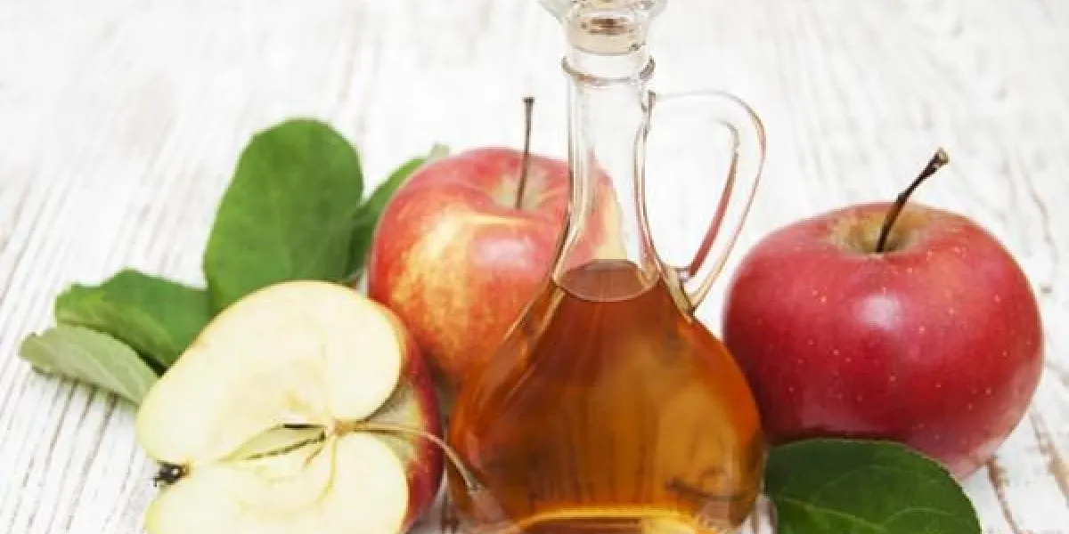 vinaigre de cidre de pomme et pomme fraîche sur un fond en bois